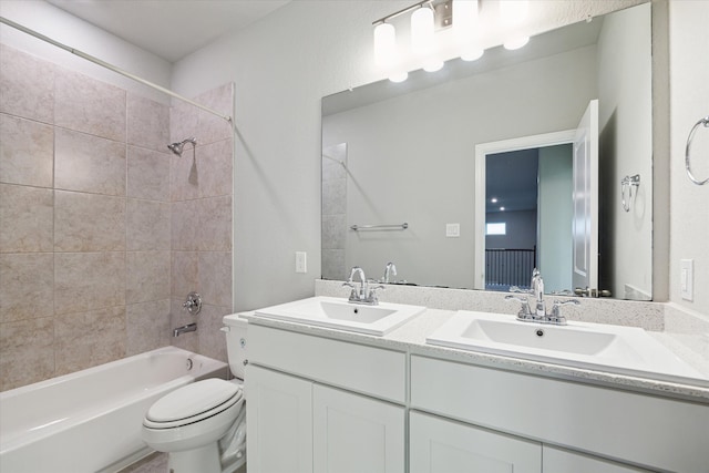 full bathroom featuring vanity, tiled shower / bath combo, and toilet