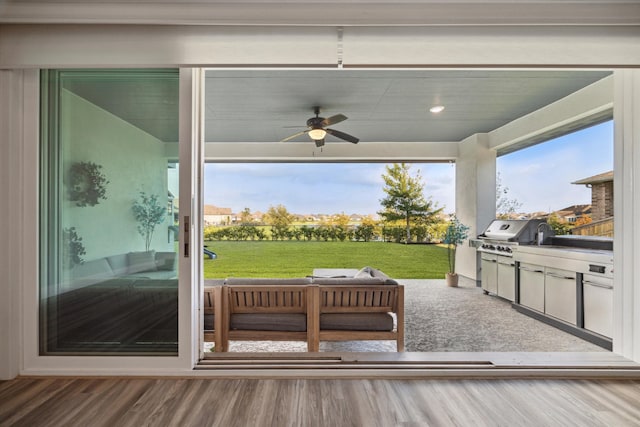 exterior space featuring an outdoor kitchen, ceiling fan, and grilling area