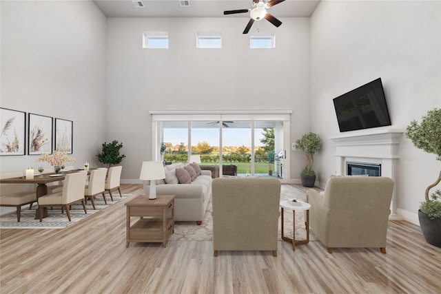 living room featuring a towering ceiling and a healthy amount of sunlight