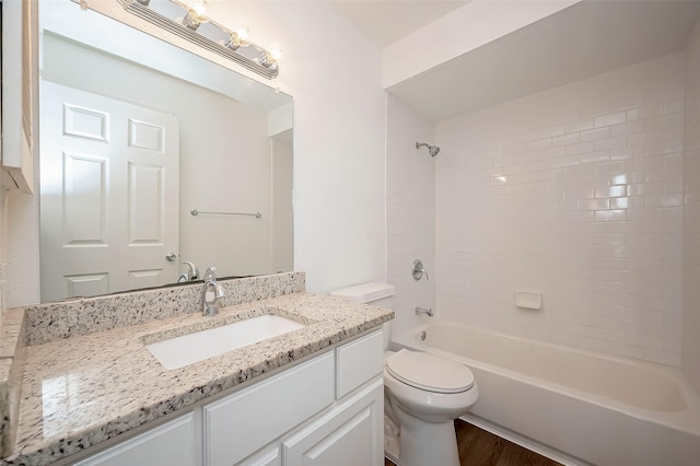 full bath featuring wood finished floors, bathing tub / shower combination, vanity, and toilet
