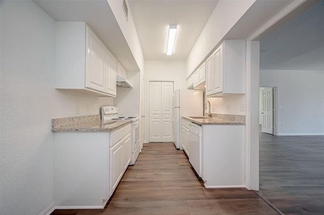 kitchen featuring exhaust hood, wood finished floors, a sink, white appliances, and white cabinetry