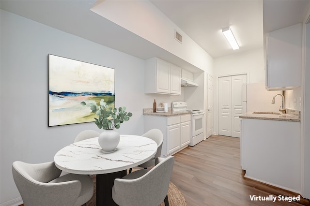 dining space featuring light hardwood / wood-style flooring and sink