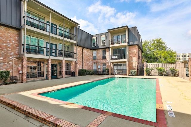 pool featuring fence and a patio