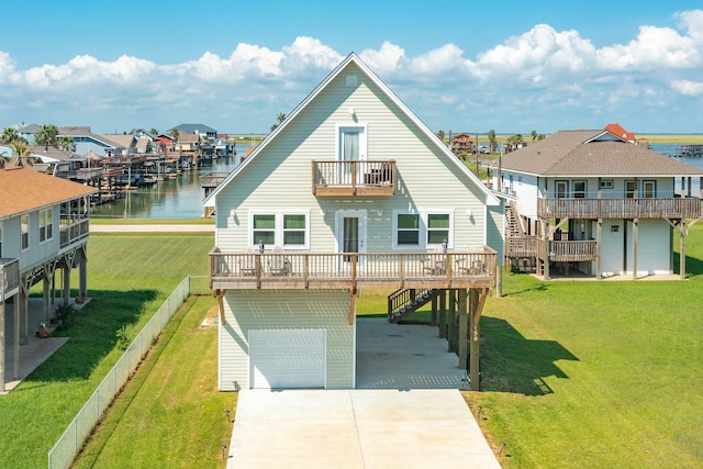 back of house featuring a water view, a balcony, a garage, and a lawn