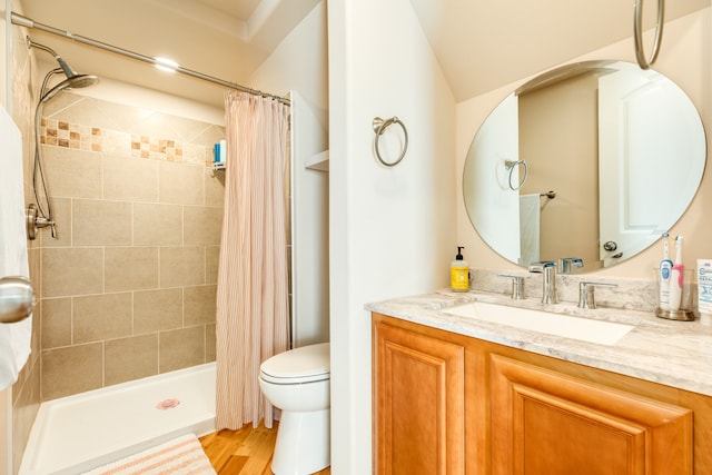 bathroom featuring walk in shower, hardwood / wood-style flooring, vanity, and toilet