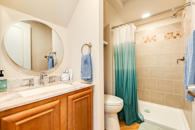 bathroom featuring vanity, lofted ceiling, wood-type flooring, walk in shower, and toilet