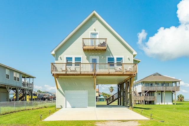 rear view of house with a lawn, a balcony, and a garage