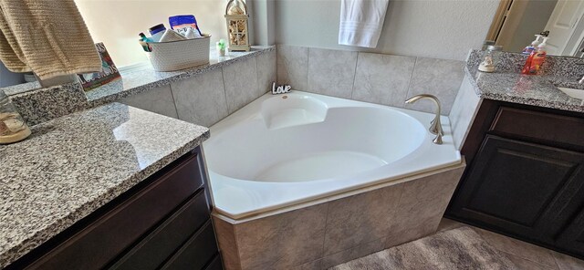 bathroom with tiled bath and vanity