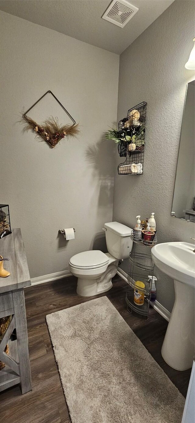 bathroom with toilet and hardwood / wood-style flooring