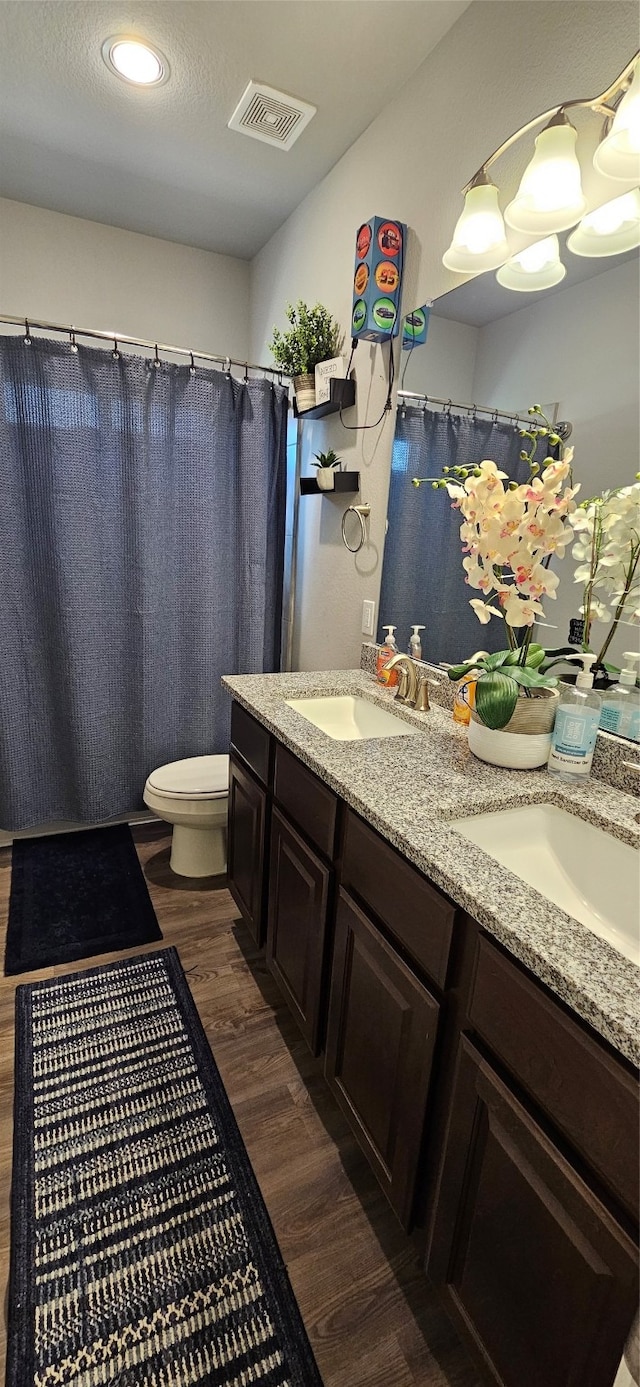 bathroom with vanity, a textured ceiling, hardwood / wood-style floors, and toilet