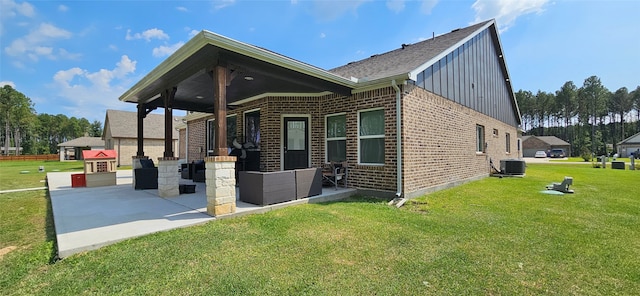 back of house with central air condition unit and a yard