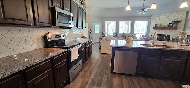 kitchen featuring hanging light fixtures, dark hardwood / wood-style flooring, stainless steel appliances, dark brown cabinetry, and sink