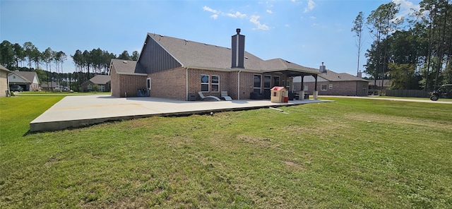 rear view of house featuring a yard, a wooden deck, and a patio area