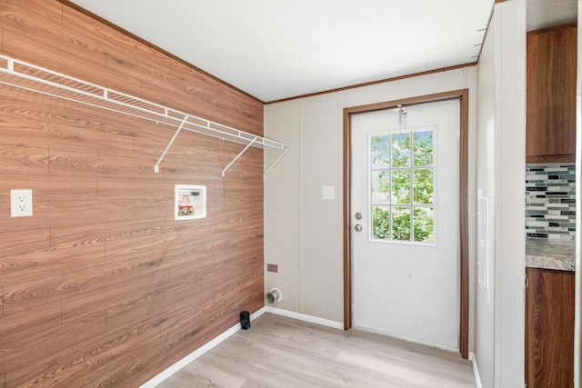 laundry room with washer hookup, wooden walls, and light hardwood / wood-style floors