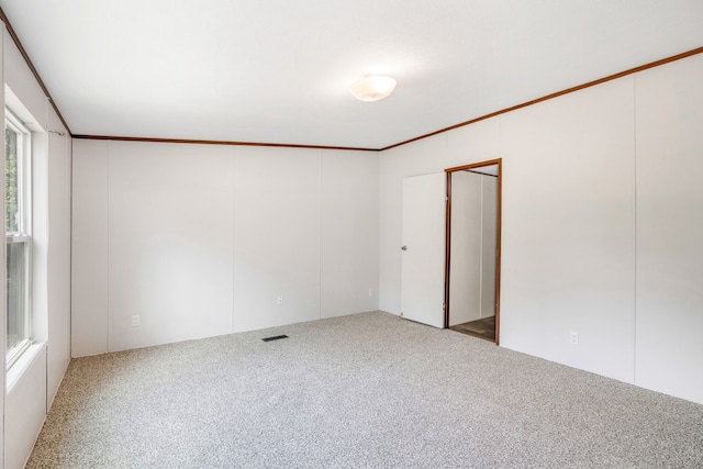 carpeted empty room featuring crown molding