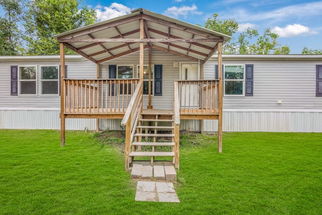 rear view of house with a deck and a yard