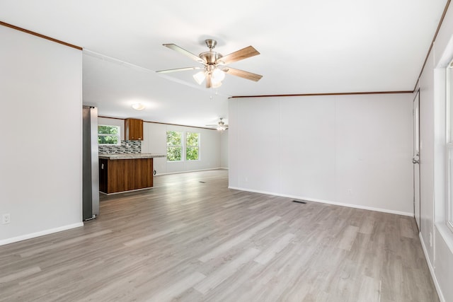 unfurnished living room with ornamental molding, light wood-type flooring, and ceiling fan