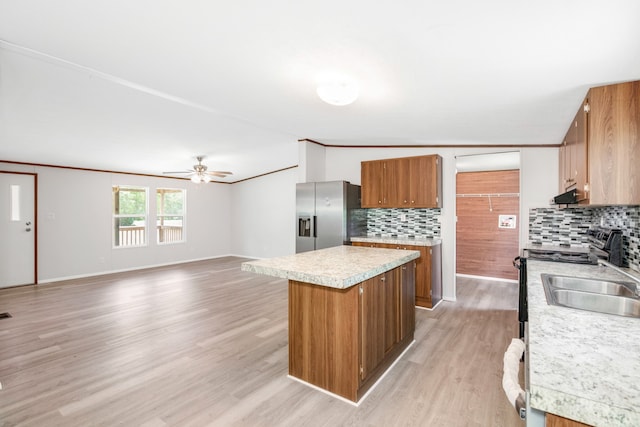 kitchen with ceiling fan, sink, light hardwood / wood-style flooring, stainless steel appliances, and decorative backsplash