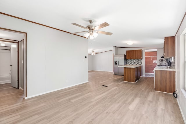 kitchen with stainless steel refrigerator with ice dispenser, ceiling fan, light hardwood / wood-style floors, and backsplash