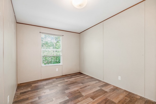 empty room featuring crown molding and hardwood / wood-style flooring