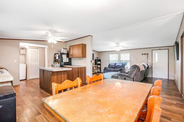 dining area featuring washer / dryer, ceiling fan, hardwood / wood-style floors, and crown molding