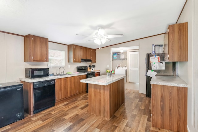 kitchen with ceiling fan, sink, a kitchen island, wood-type flooring, and black appliances