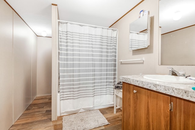 bathroom with shower / tub combo, hardwood / wood-style flooring, and vanity