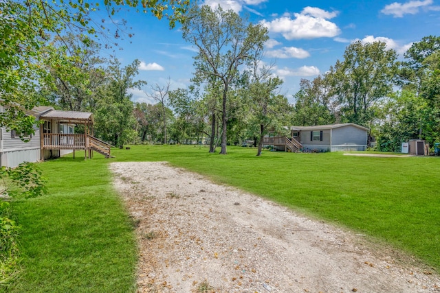 view of yard featuring a wooden deck and a shed