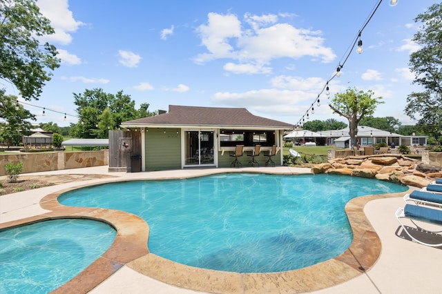 view of pool with exterior bar and a patio