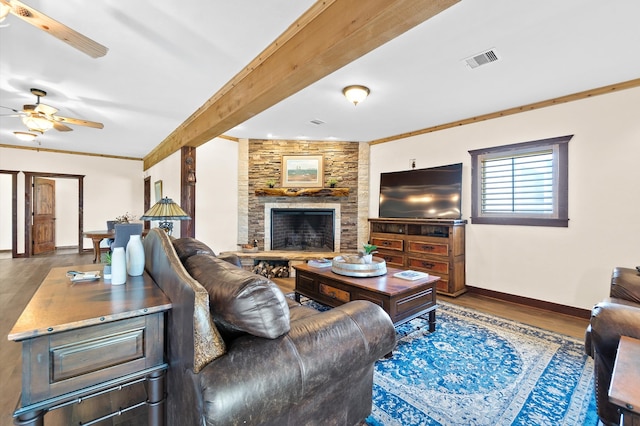 living room featuring ceiling fan, a stone fireplace, ornamental molding, and hardwood / wood-style floors