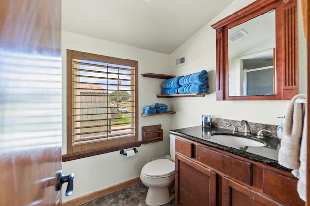 bathroom with lofted ceiling, vanity, and toilet