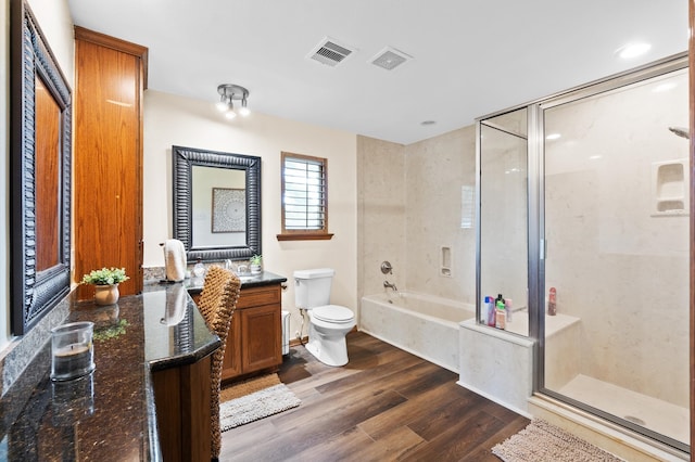 full bathroom featuring wood-type flooring, vanity, plus walk in shower, and toilet