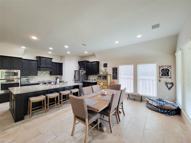 dining space with lofted ceiling and light tile patterned floors