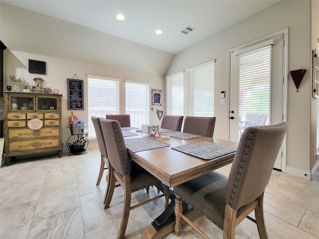 dining space featuring vaulted ceiling and plenty of natural light