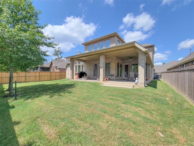 back of house featuring a yard, ceiling fan, and a patio area