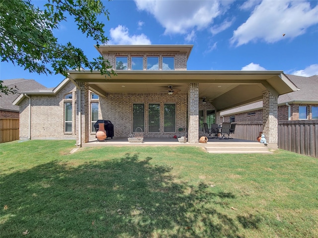 back of house featuring ceiling fan, a lawn, and a patio area