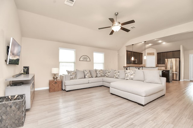 living room featuring light hardwood / wood-style flooring, vaulted ceiling, and ceiling fan