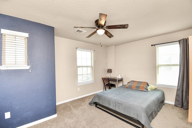 bedroom featuring light carpet, multiple windows, and ceiling fan