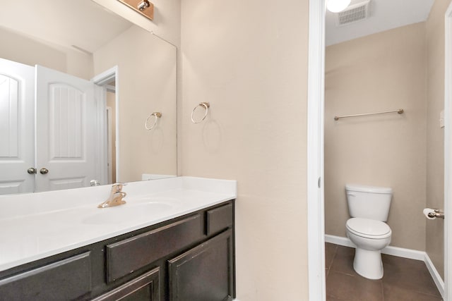 bathroom with tile patterned flooring, vanity, and toilet