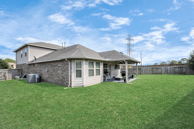 back of house with a patio, a lawn, and central air condition unit