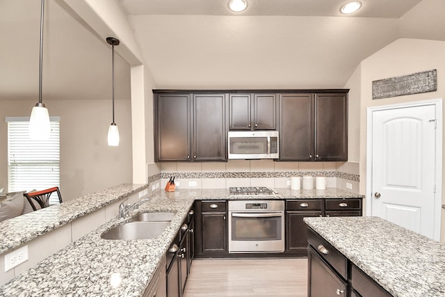 kitchen with sink, dark brown cabinets, decorative light fixtures, appliances with stainless steel finishes, and vaulted ceiling