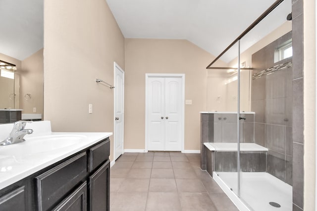 bathroom with tile patterned flooring, vaulted ceiling, walk in shower, and vanity