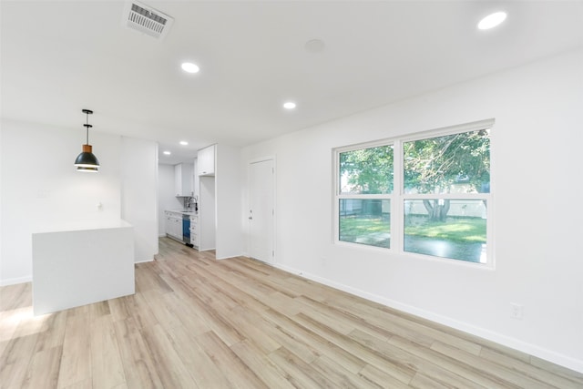 unfurnished living room with light hardwood / wood-style flooring and sink