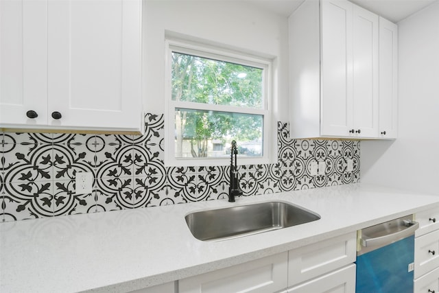 kitchen featuring dishwasher, light stone counters, sink, white cabinets, and decorative backsplash