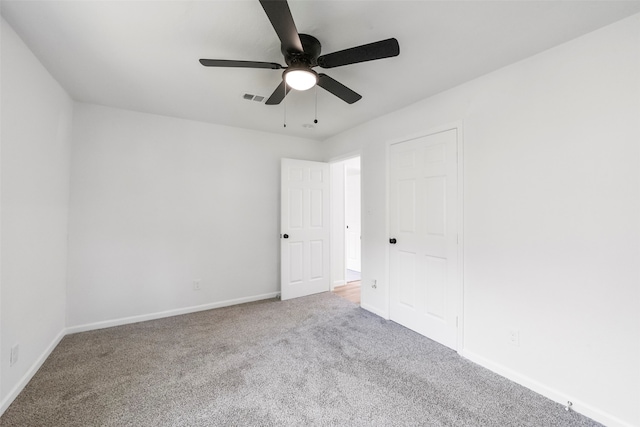 carpeted spare room featuring ceiling fan