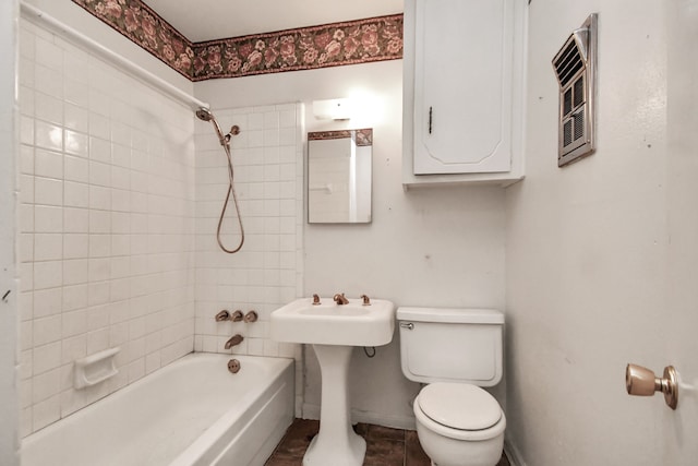 bathroom featuring toilet and tiled shower / bath