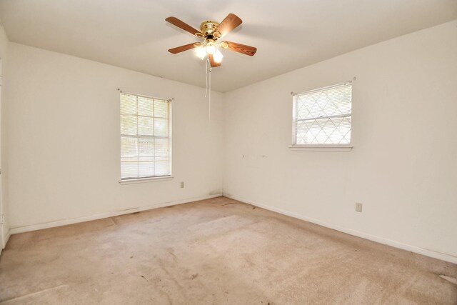 carpeted empty room with ceiling fan and a healthy amount of sunlight