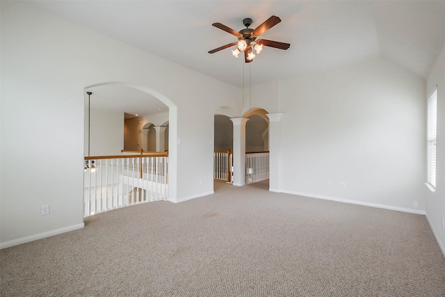 empty room featuring a ceiling fan, baseboards, ornate columns, arched walkways, and carpet floors