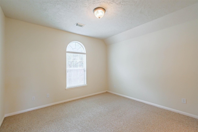 empty room with a textured ceiling, visible vents, carpet, and baseboards
