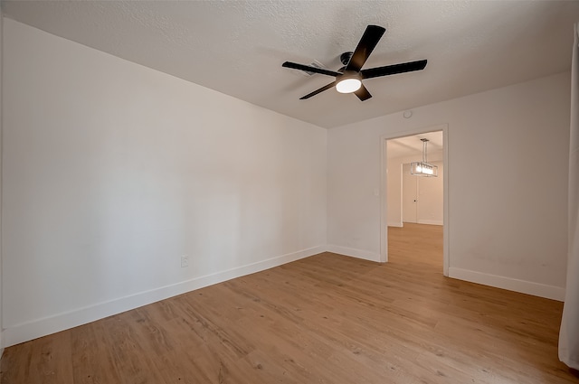 unfurnished room with a textured ceiling, light hardwood / wood-style floors, and ceiling fan